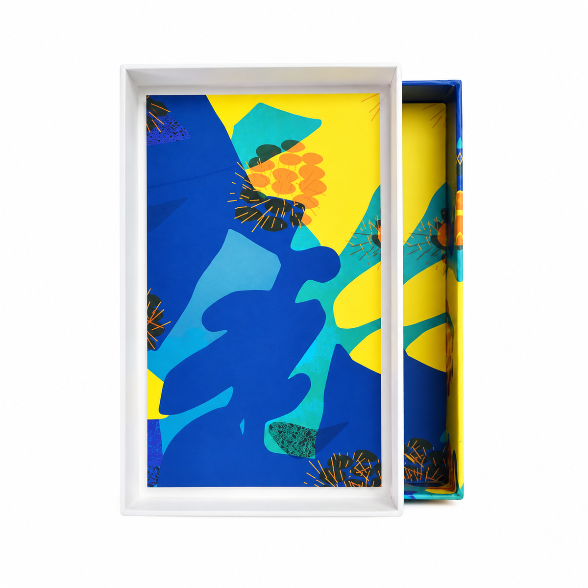 Coffret de Bleu de Bleu de Noème Paris ouvert, intérieur illustré de formes bleues, turquoise et jaunes, sur fond blanc.