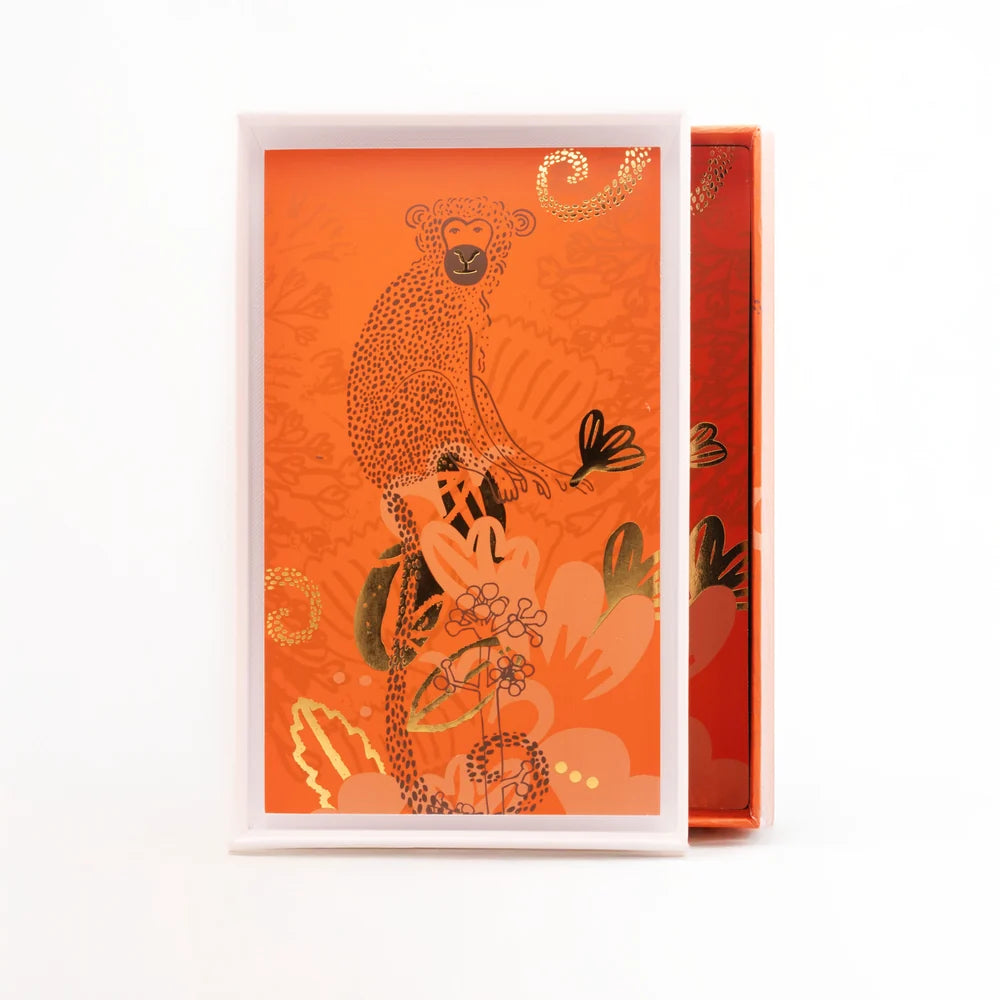 Coffret de Kalahari Extrême de Noème Paris ouvert, intérieur orange illustré d'un singe et de feuillages dorés, sur fond blanc.