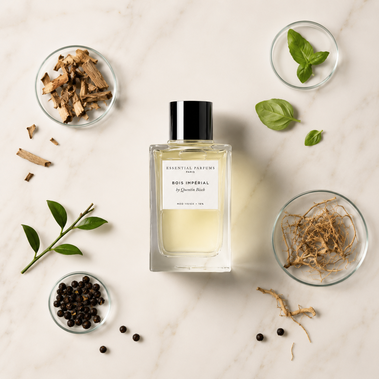 Bois Impérial d'Essential Parfums, eau de parfum 100 ml, mis en scène avec ses ingrédients naturels sur un fond marbre blanc : feuilles de basilic, bois, résines et épices.