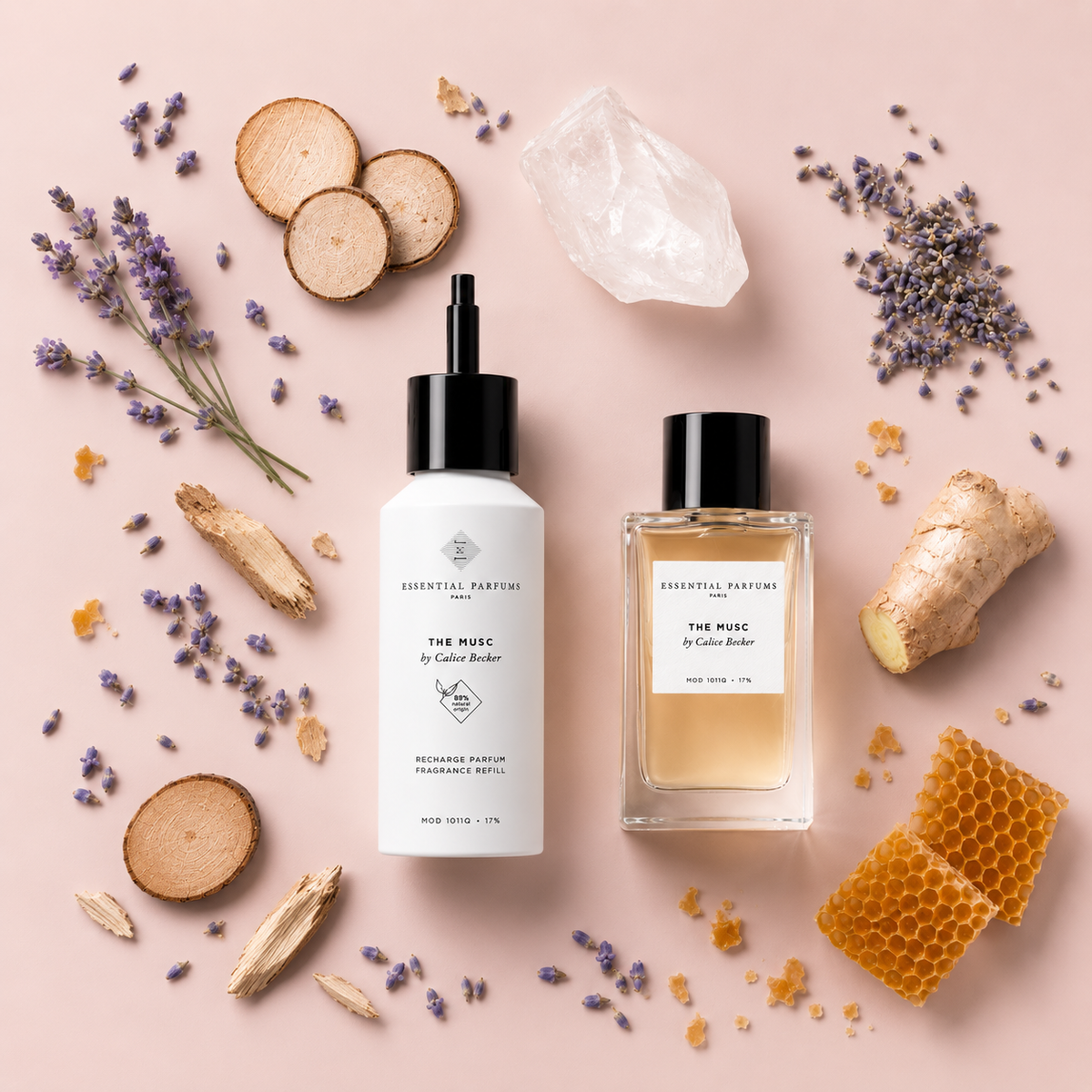 Recharge parfum The Musc 150 ml et flacon The Musc 100 ml Essential Parfums entourés de gingembre, cristal, lavande, cire d'abeille et rondelles de bois sur fond gris clair.
