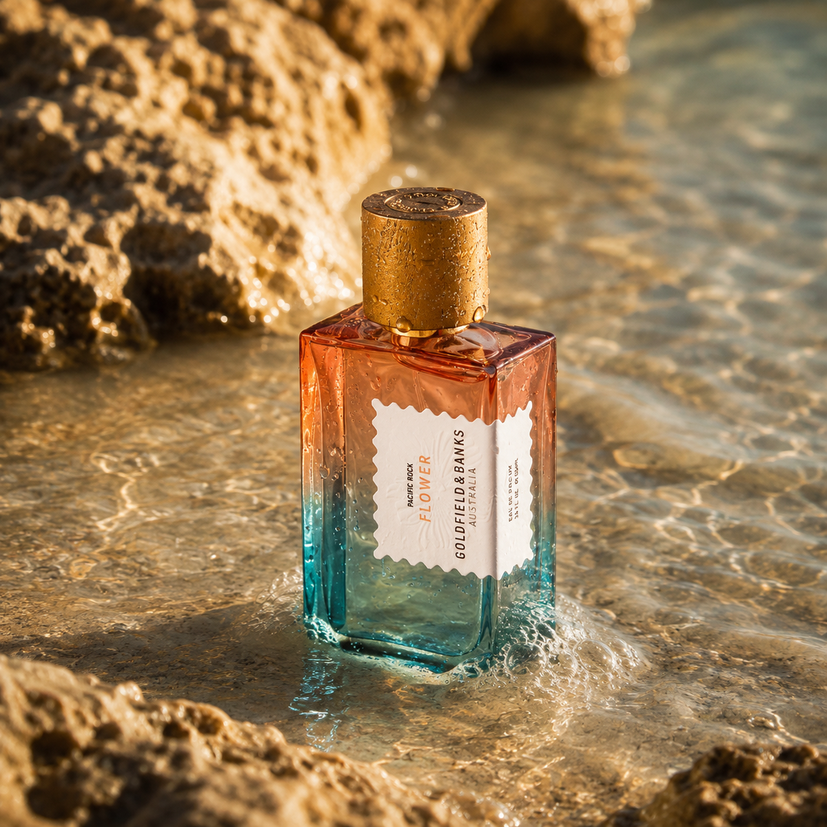 Pacific Rock Flower de Goldfield & Banks, eau de parfum, flacon en mise en scène dans l'eau entre des rochers.