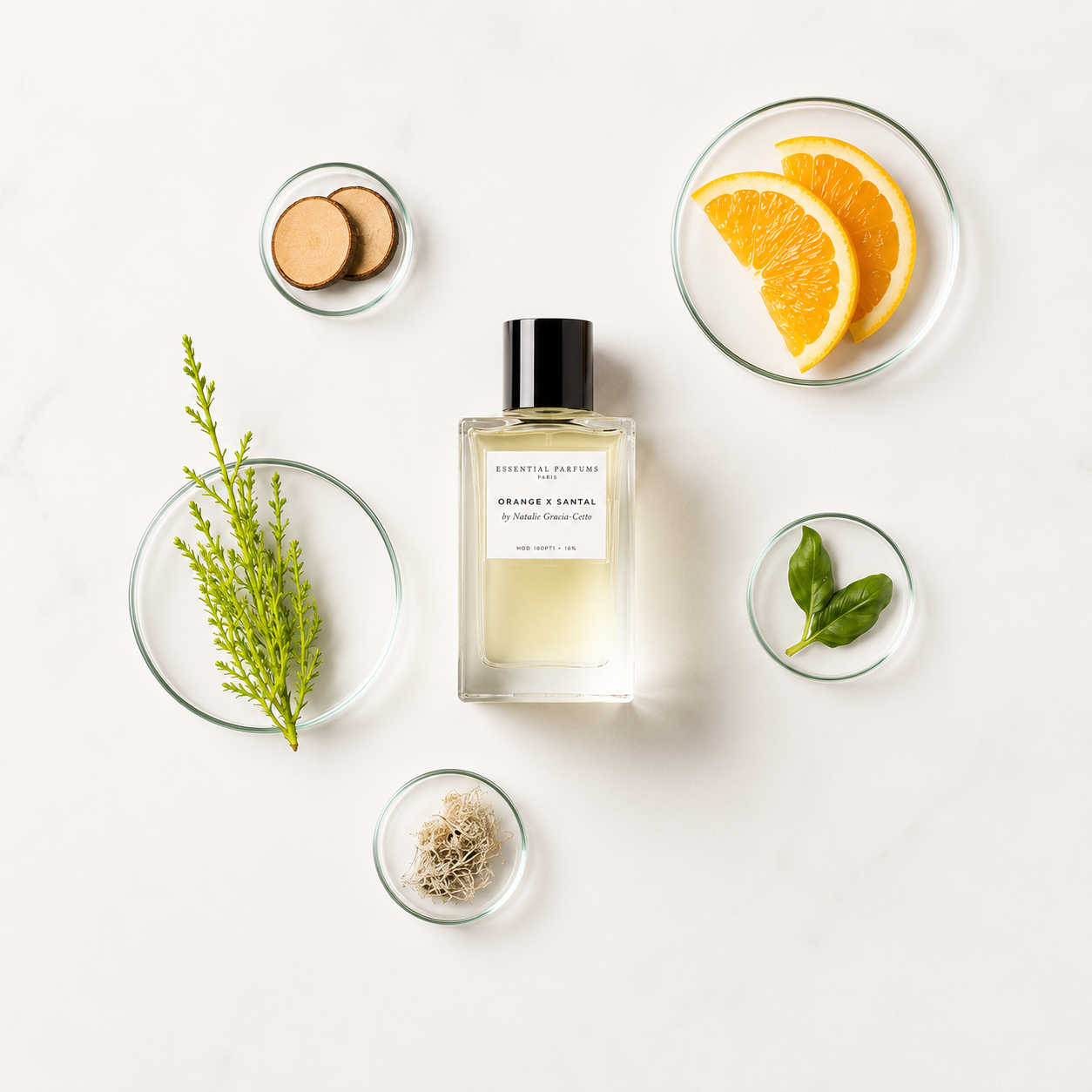 Orange X Santal d'Essential Parfums, eau de parfum 100 ml entourée d'orange douce, bois de santal, basilic, cyprès et mousse de chêne sur fond clair.