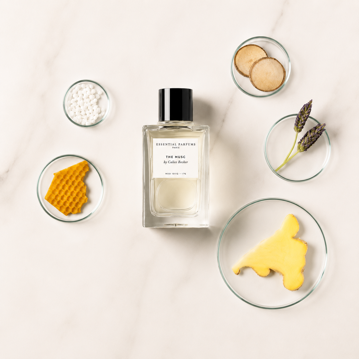 The Musc d'Essential Parfums, eau de parfum 100 ml entourée de cire d'abeille, gingembre, lavande, bois de santal et muscs sur fond clair.