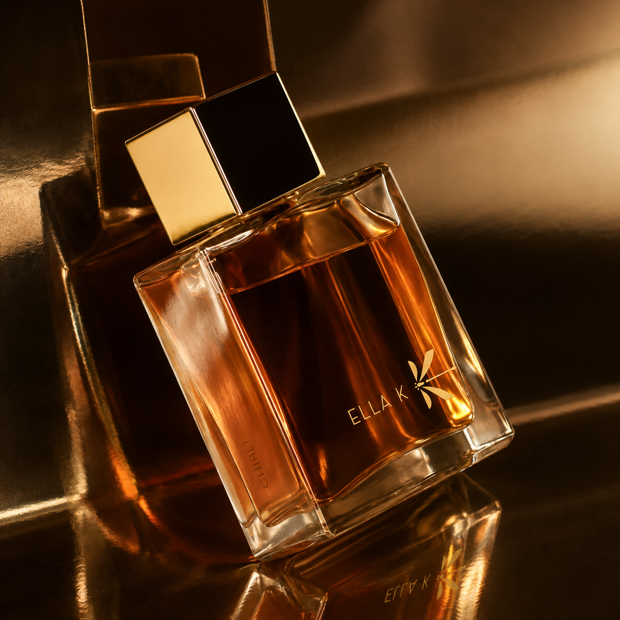 Parfum Ghibli Ella K posé sur une surface dorée réfléchissante dans une ambiance ambrée et lumineuse