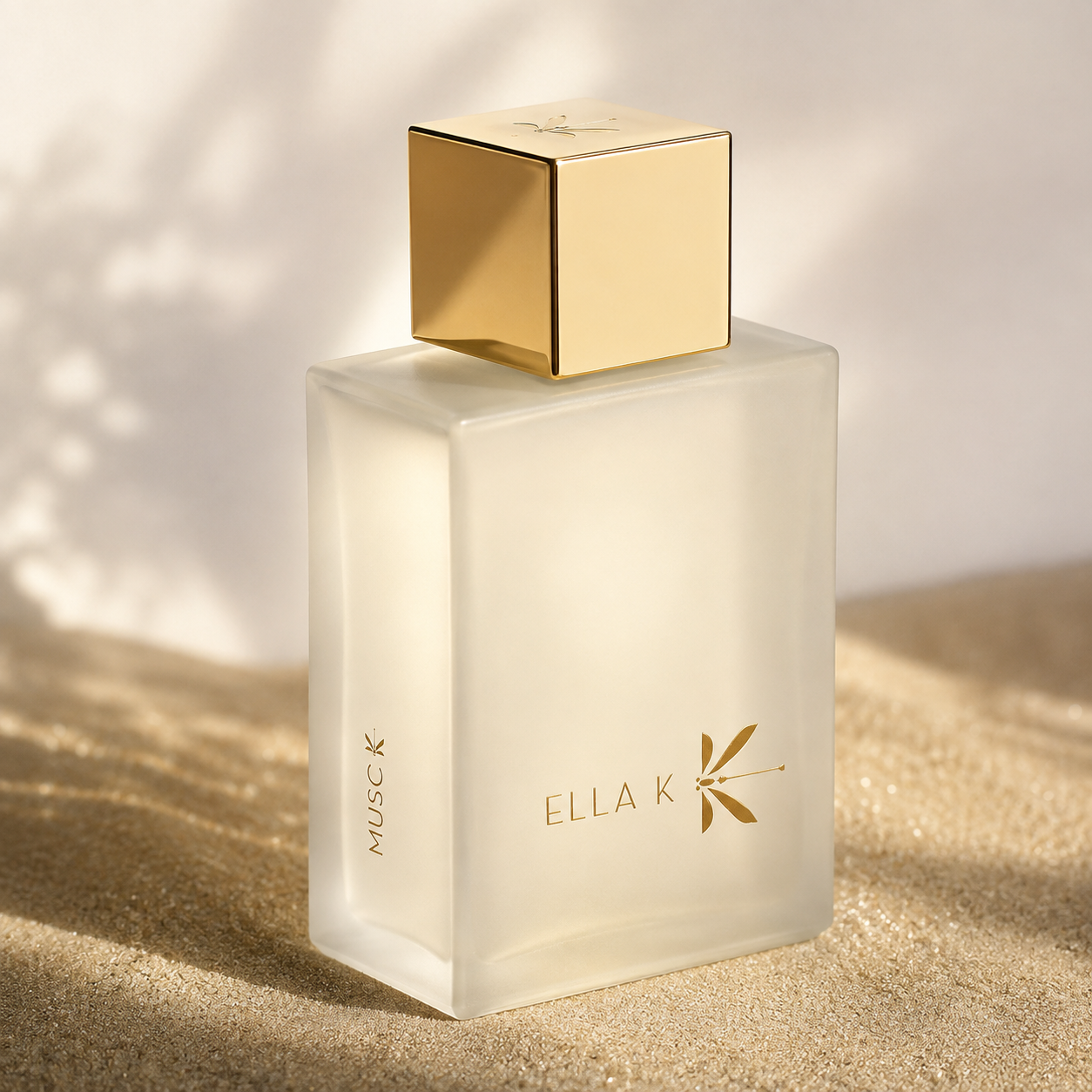 Musc K d'Ella K, eau de parfum, flacon en mise en scène sur une surface dorée aux tons crème.