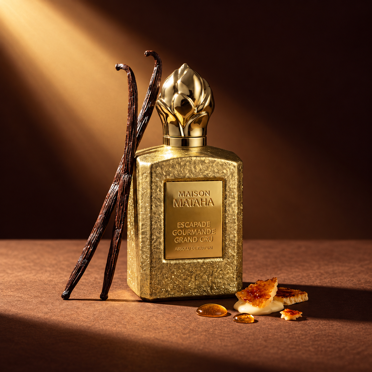 Escapade Gourmande Grand Cru de Maison Mataha, absolu de parfum 100 ml, mise en scène avec gousses de vanille et éclats de crème brûlée.