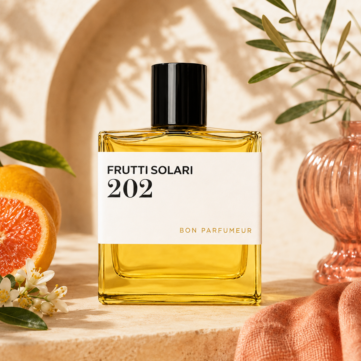 202 Frutti Solari de Bon Parfumeur, eau de parfum 100 ml, flacon en mise en scène avec agrumes et fleur d'oranger.