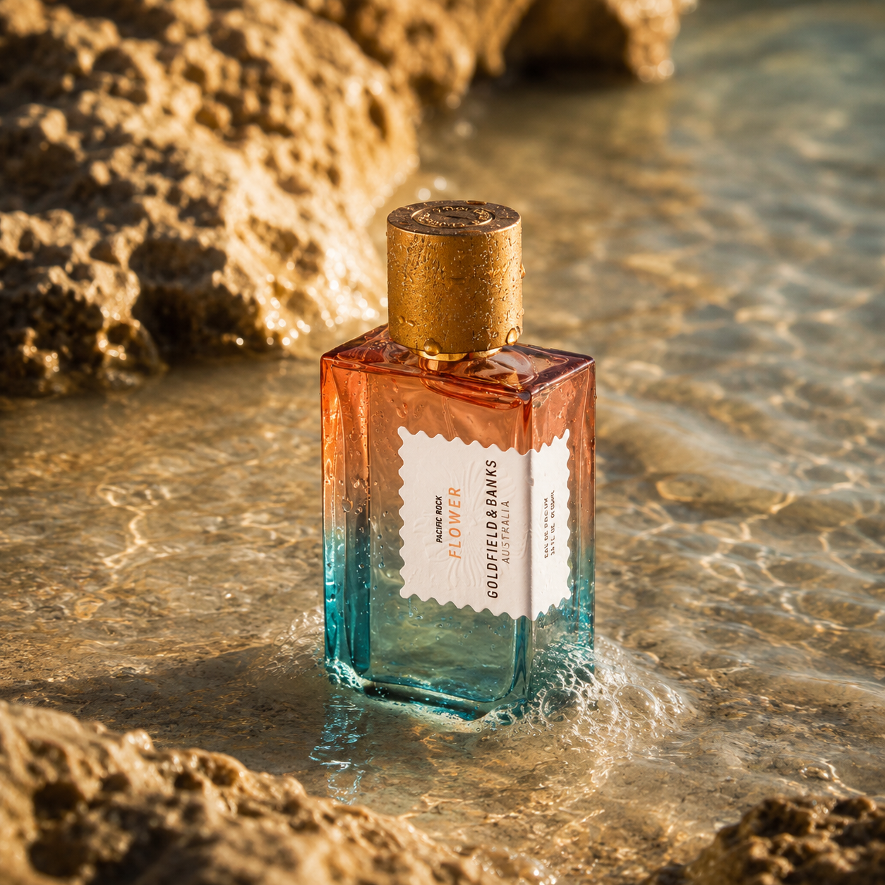 Parfum Pacific Rock Flower Goldfield & Banks Australia en mise en scène dans l’eau entre des rochers avec lumière dorée