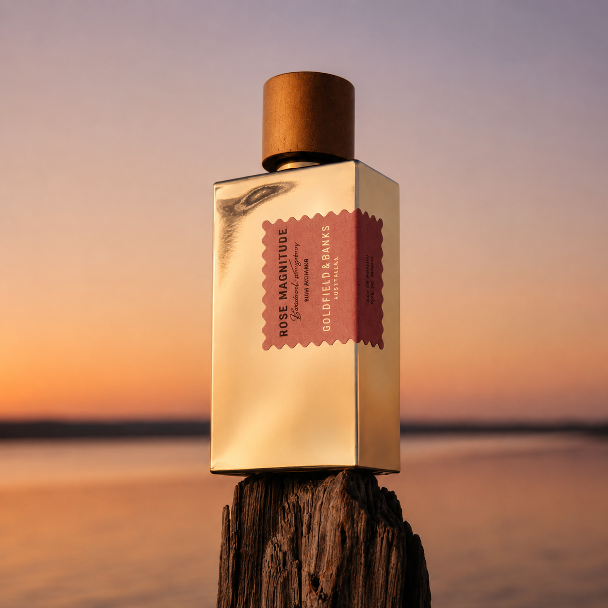Parfum Rose Magnitude Goldfield & Banks Australia en mise en scène sur bois face au coucher de soleil