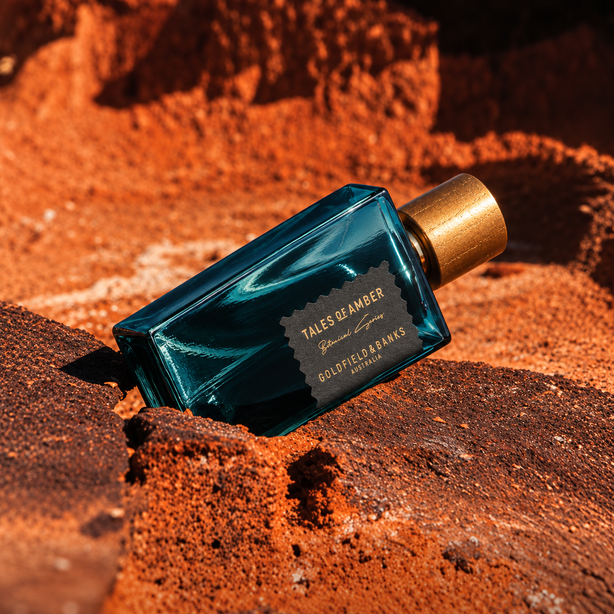 Parfum Tales of Amber Goldfield & Banks Australia en mise en scène sur roches rouges aux tons chauds et ambrés