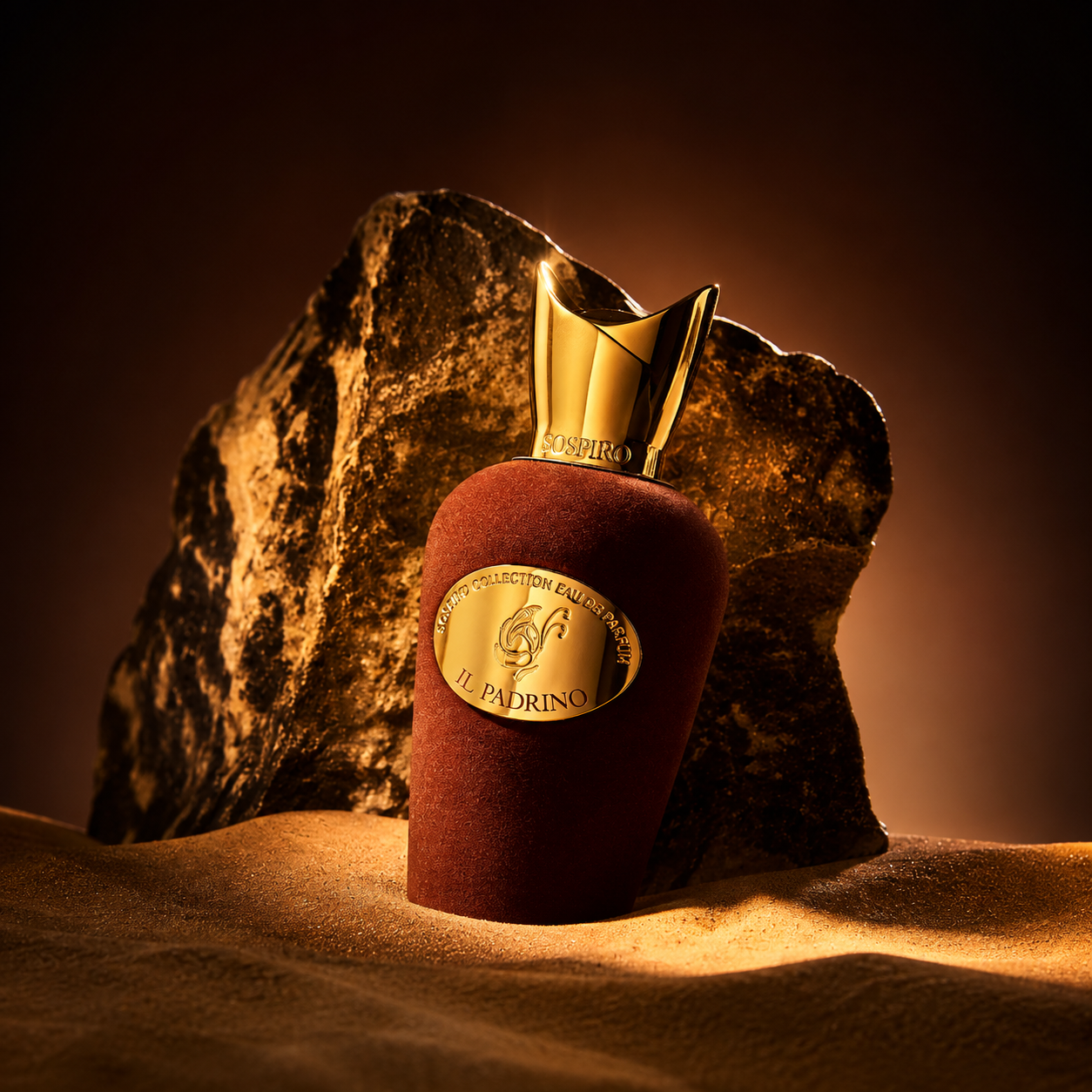 Il Padrino de Sospiro, eau de parfum 100 ml, flacon en mise en scène sur le sable devant une roche dorée.
