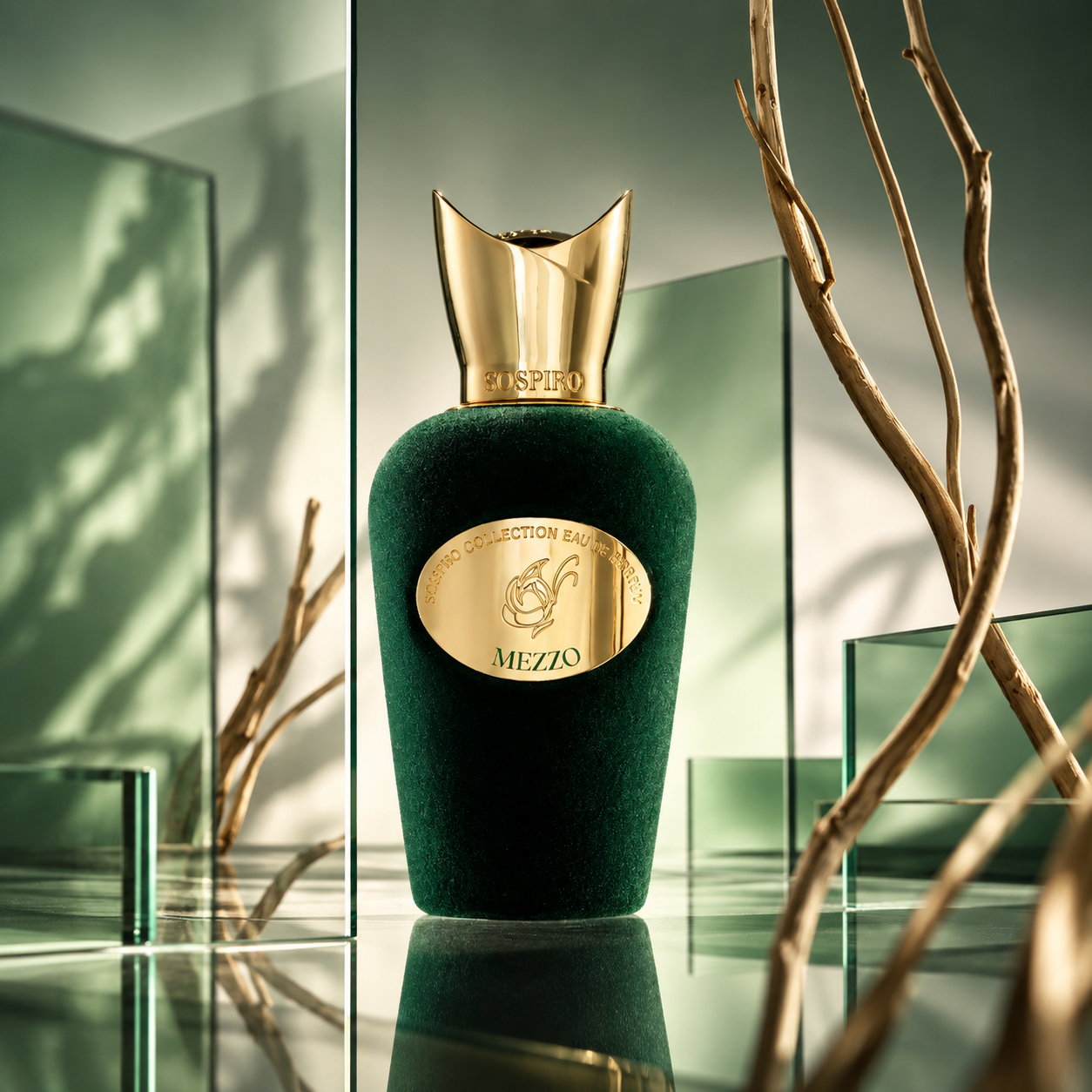 Mezzo de Sospiro, eau de parfum 100 ml, flacon en mise en scène entre des panneaux de verre vert et des branches dorées.