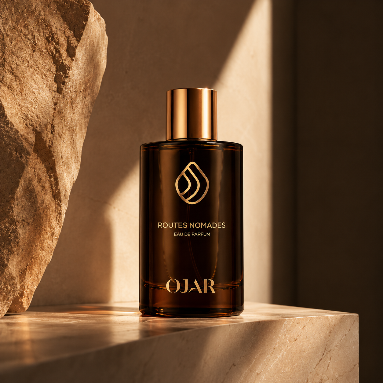 Routes Nomades d'OJAR, eau de parfum, flacon en mise en scène dans un décor minéral de pierre beige.