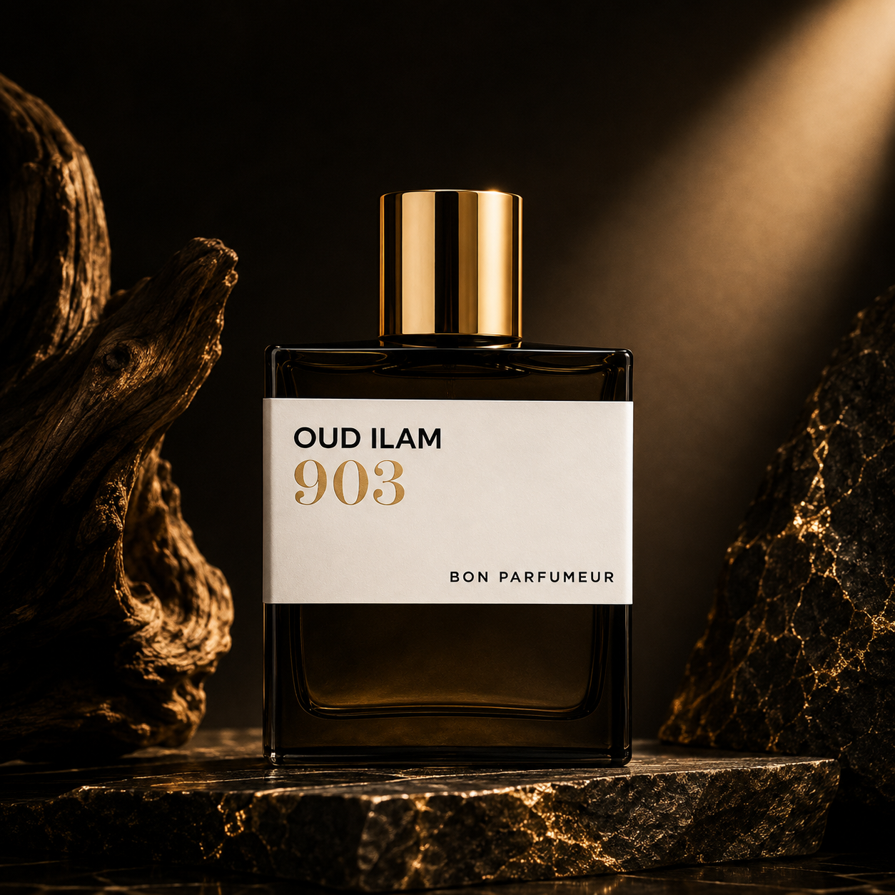 903 Oud Ilam de Bon Parfumeur, extrait de parfum 100 ml, flacon en mise en scène avec bois flotté et pierre dorée.