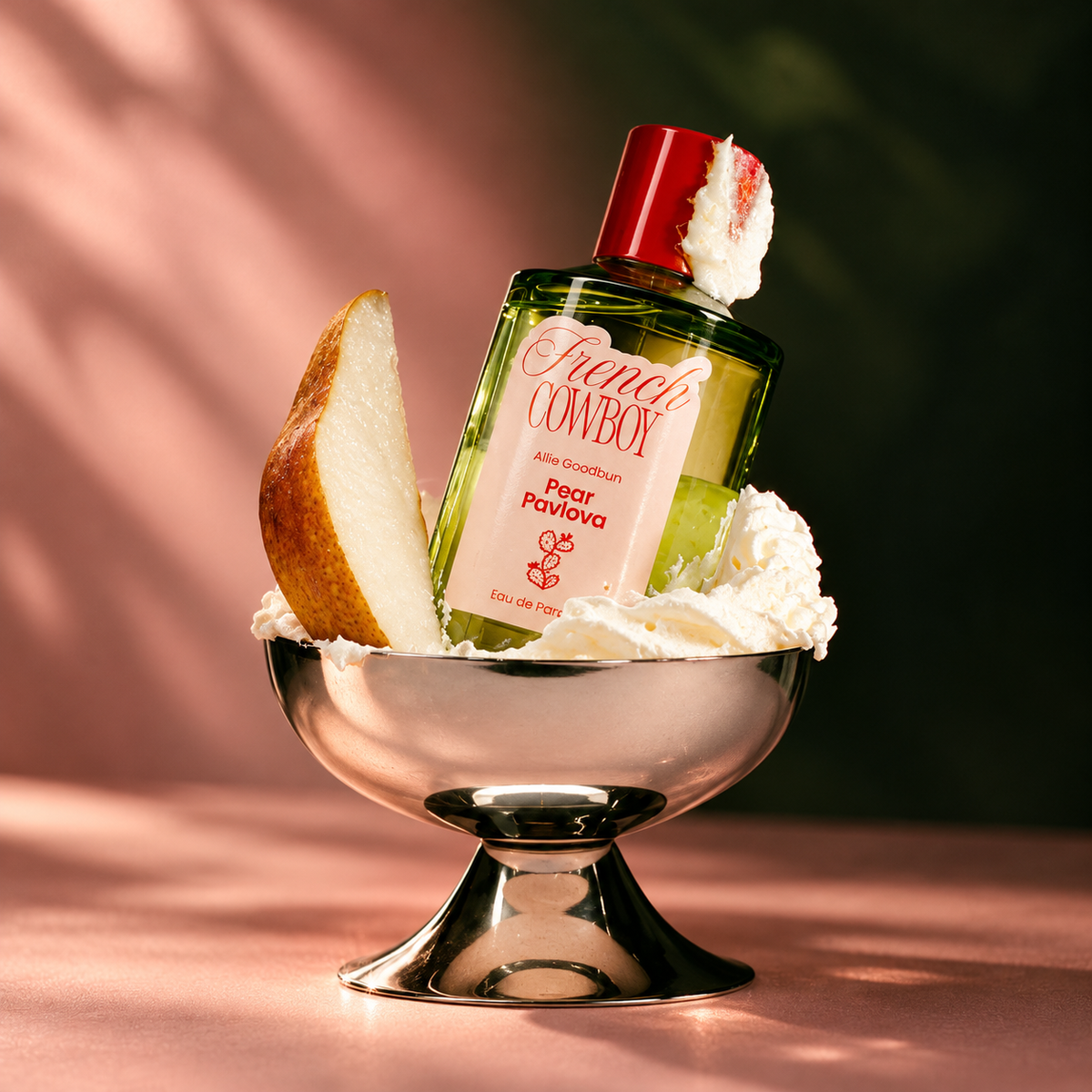 Pear Pavlova de French Cowboy, eau de parfum 100 ml, mise en scène dans une coupe de crème fouettée avec un quartier de poire.