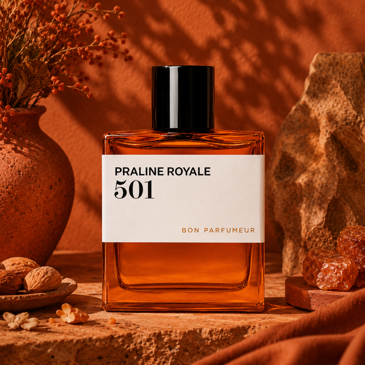 501 Praline Royale de Bon Parfumeur, eau de parfum 100 ml, flacon en mise en scène avec noisettes et terre cuite.