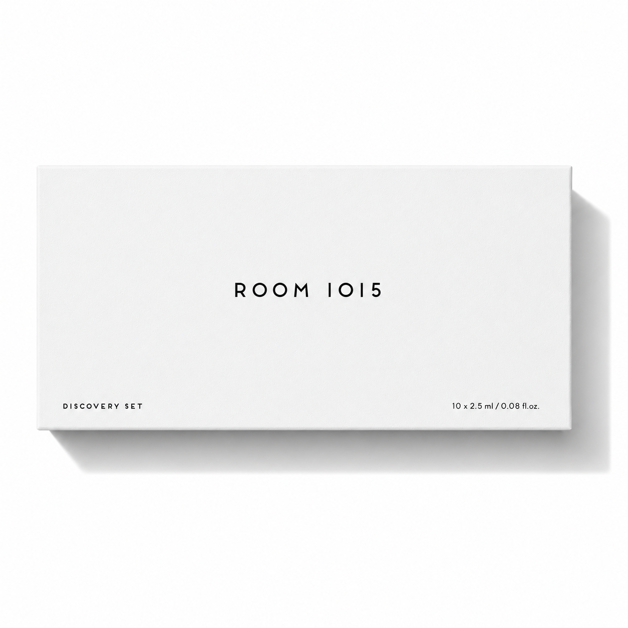 Coffret découverte Room 1015 fermé contenant 10 échantillons de parfum de 2,5 ml sur fond blanc.
