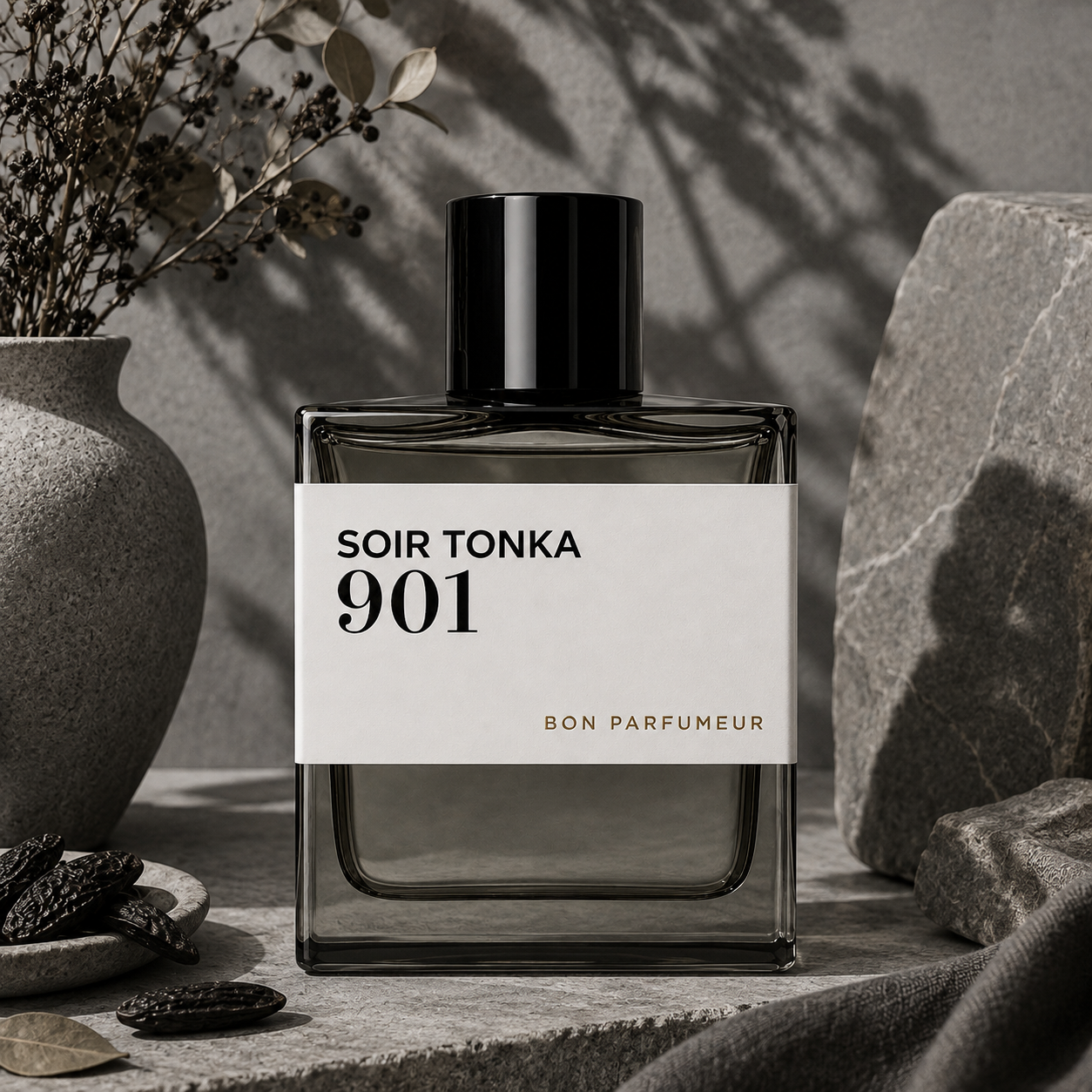 901 Soir Tonka de Bon Parfumeur, eau de parfum 100 ml, flacon en mise en scène avec fèves tonka et pierre grise.